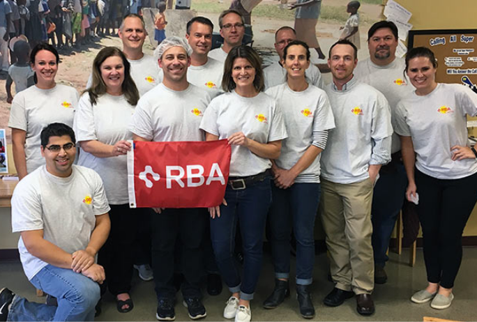 Photo of RBA emplyees volunteering and holding RBA flag